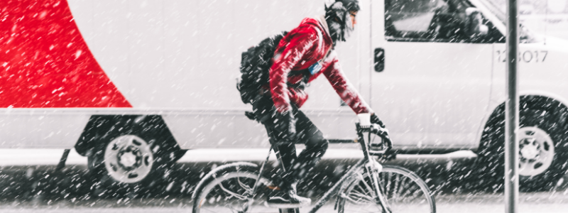 punatakkinen pyöräilijä lumisateessa